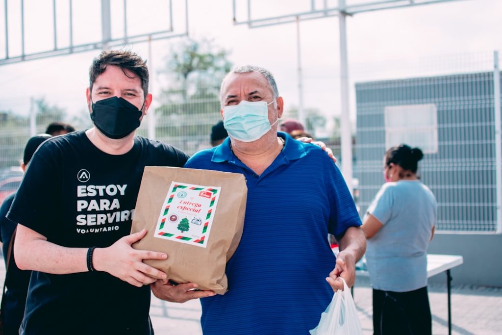 two-men-wearing-masks-and-holding-a-bag-of-food-yvamskr8wba